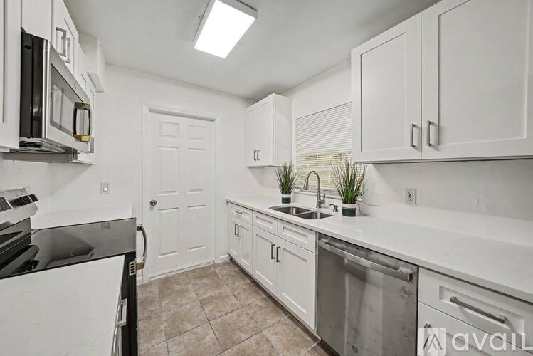 A kitchen with white cabinets and a black dishwasher.