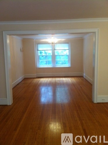A room with wooden floors and a window letting in light.