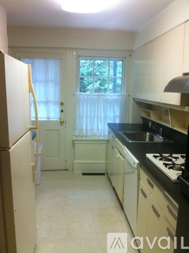 A kitchen with white cabinets and black countertops.