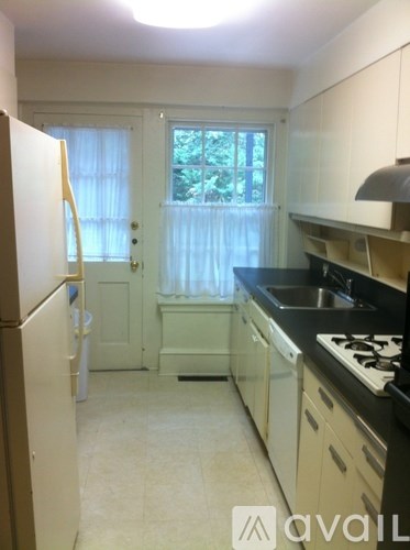 A kitchen with white cabinets and black countertops.