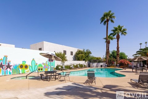 A pool area with a mural of cacti and palm trees.