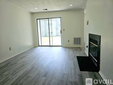 A spacious room with a fireplace and a large window.