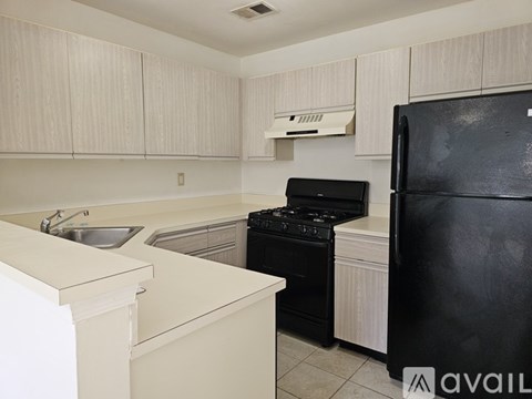 A kitchen with black appliances and white cabinets.