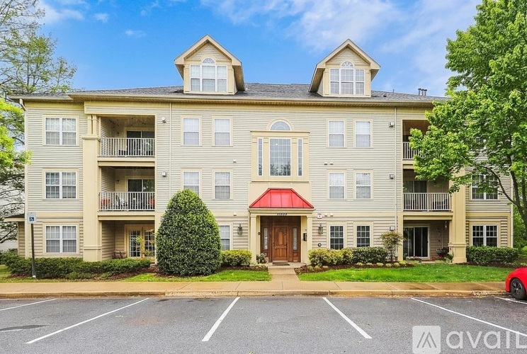 A large apartment building with a red awning in front.