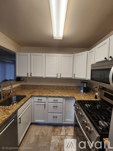 A kitchen with white cabinets and a granite countertop.