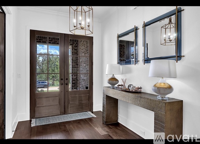 A wooden door with glass panels and a bench with a lamp on it.