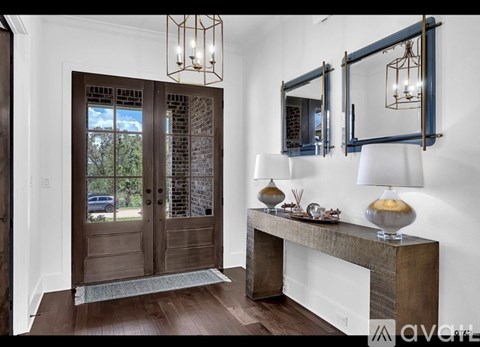 A wooden door with glass panels and a bench with a lamp on it.