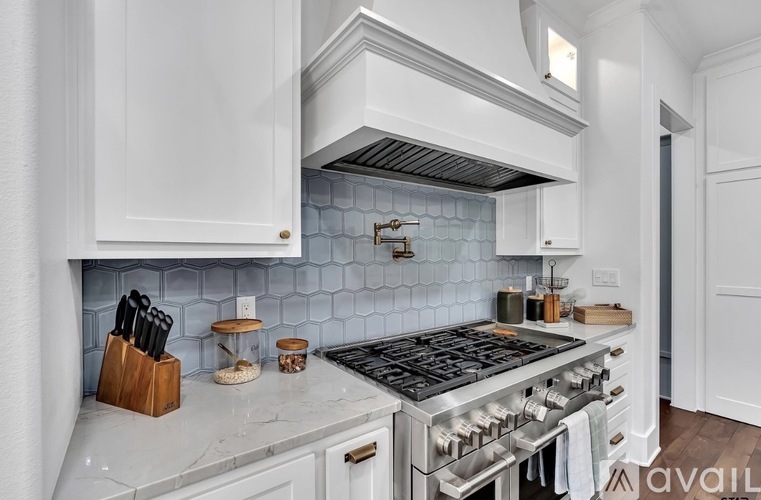 A kitchen with a stove top oven and a hood above it.