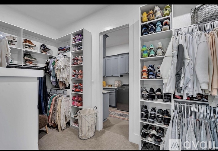 A spacious walk-in closet with organized shelves and a variety of clothing and shoes.