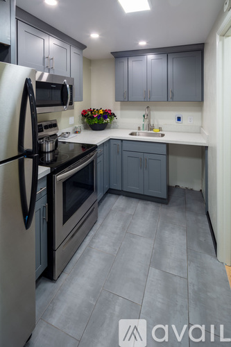 A kitchen with a refrigerator, oven, and sink.