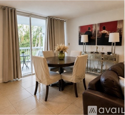 A dining room with a table set for two and a couch.