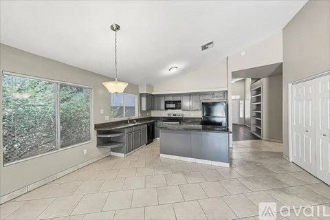 A spacious kitchen with a large island and stainless steel appliances.