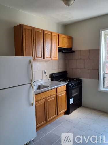 A kitchen with wooden cabinets and a white refrigerator.