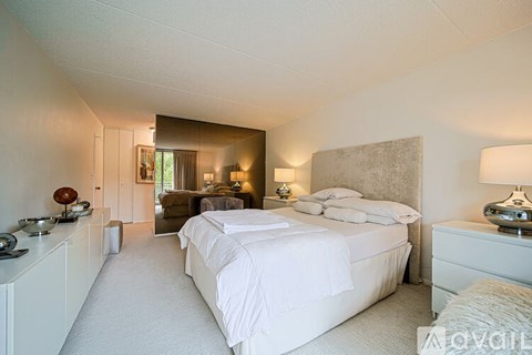 A bedroom with a large bed and a mirror on the wall.