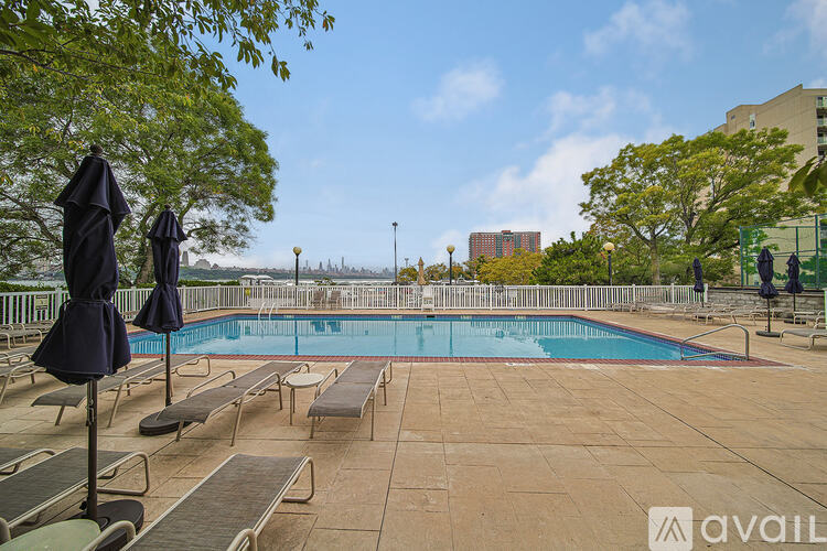 A pool area with sun loungers and umbrellas.