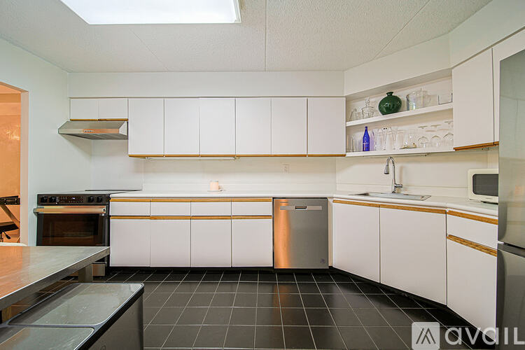 A kitchen with white cabinets and a black tile floor.