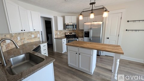 A kitchen with a sink, stove, and refrigerator.