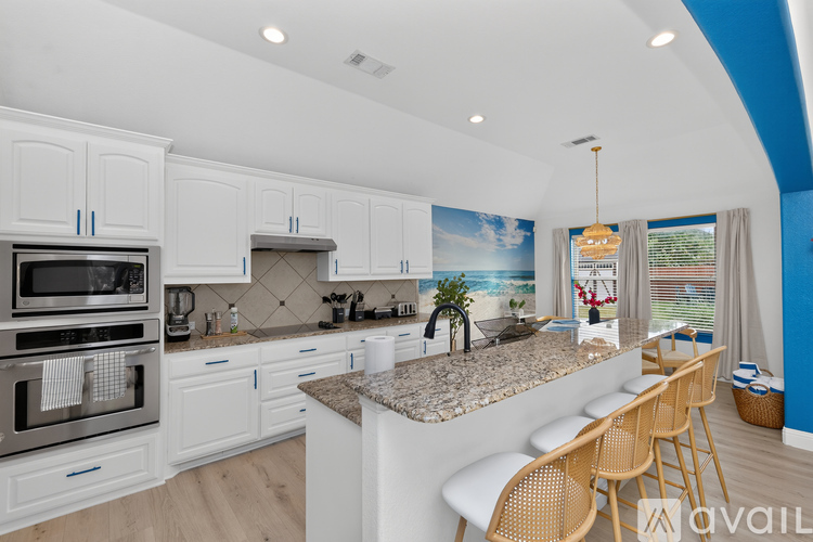 A kitchen with white cabinets and a granite countertop.
