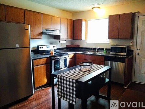 A kitchen with wooden cabinets and a black and white checkered tablecloth.