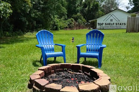 Two blue chairs are placed in front of a fire pit.