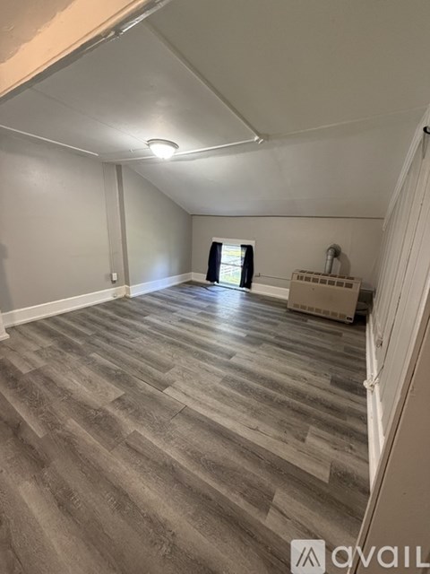 A room with wooden flooring and a window.