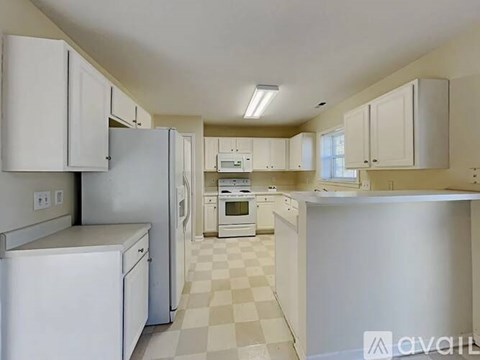 A kitchen with white appliances and cabinets.