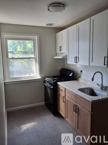 A kitchen with a black dishwasher and a window.