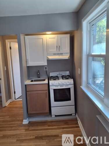 A kitchen with a white stove and wooden cabinets.