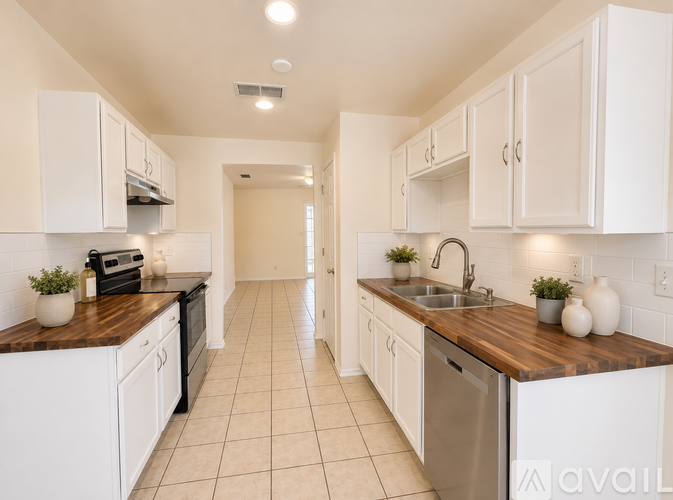 A kitchen with white cabinets and a wooden counter top.