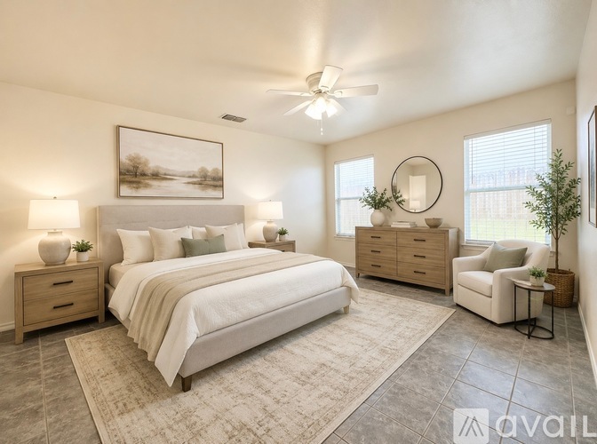 A bedroom with a large bed, a chair, and a painting on the wall.