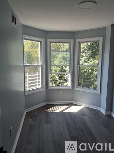 A room with a window and a wooden floor.