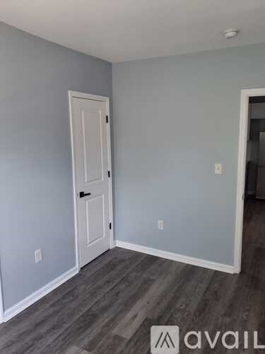 A room with a white door and grey walls.