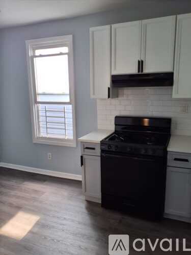 A kitchen with a black stove top oven and white cabinets.