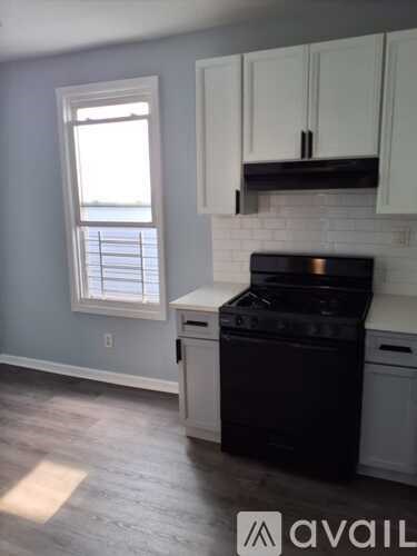 A kitchen with a black stove top oven and white cabinets.