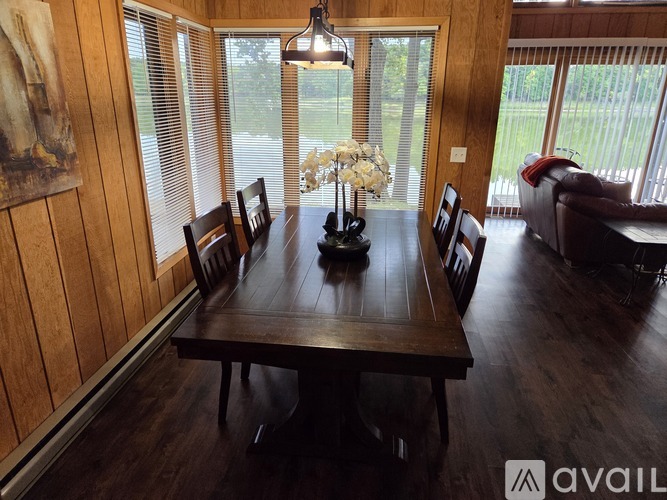 A dining room with a wooden table and chairs.