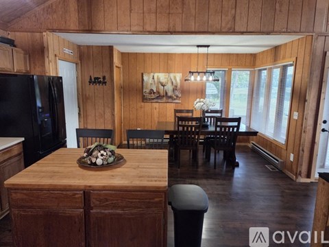 A kitchen with wooden cabinets and a black refrigerator.