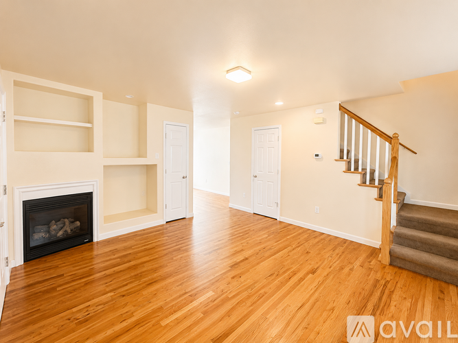 A living room with a fireplace and a staircase.