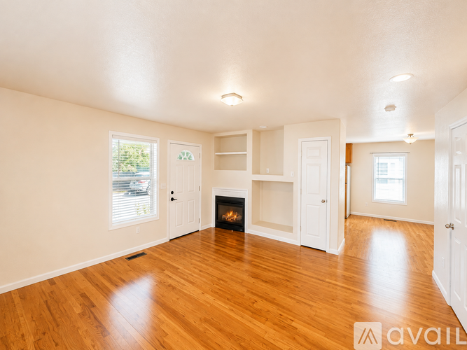 A spacious living room with a fireplace and built-in shelves.
