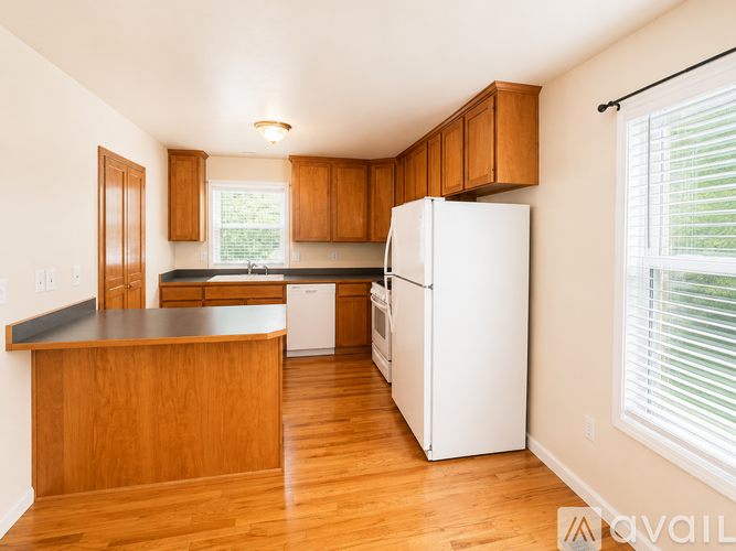 A kitchen with wooden cabinets and a white refrigerator.