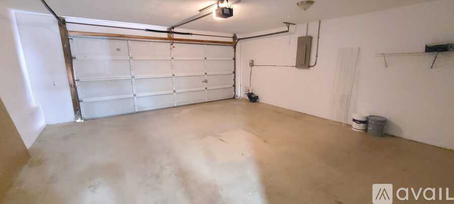 A spacious garage with a white door and a concrete floor.