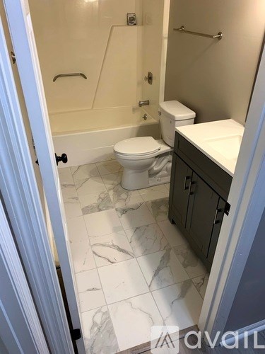 A bathroom with a toilet, sink and bathtub.
