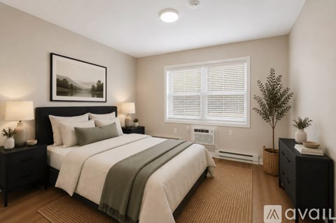 A bedroom with a large bed, two nightstands, and a framed picture on the wall.