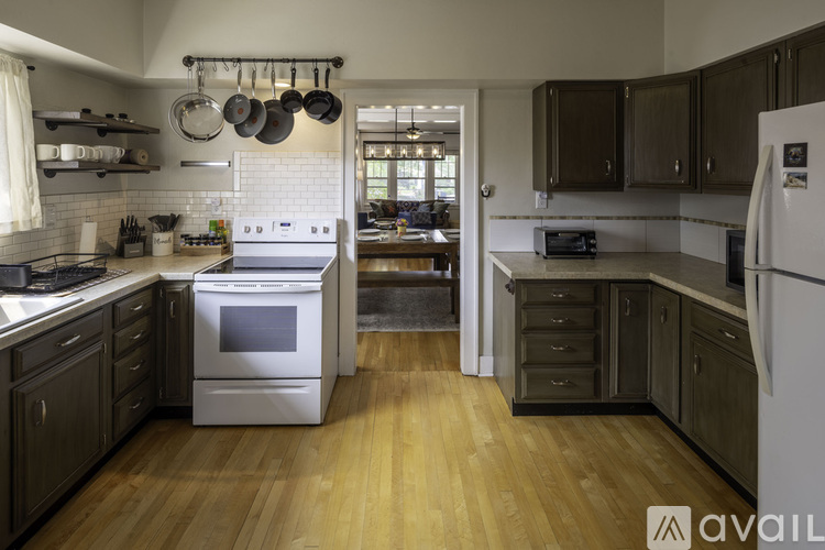 A kitchen with wooden floors and a white refrigerator.