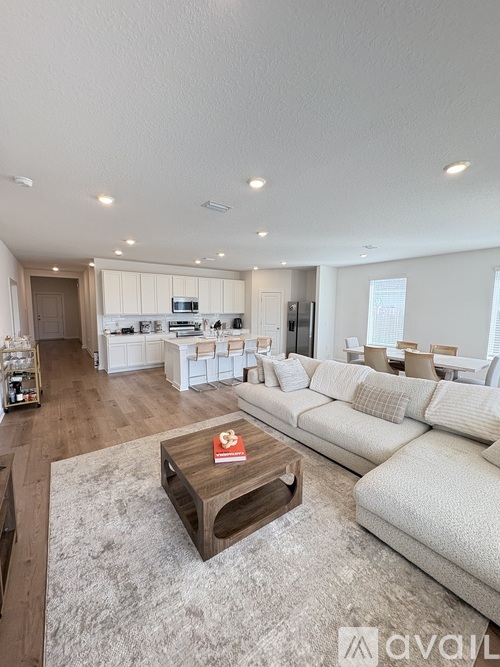 A modern living room with a white sofa and a wooden coffee table.