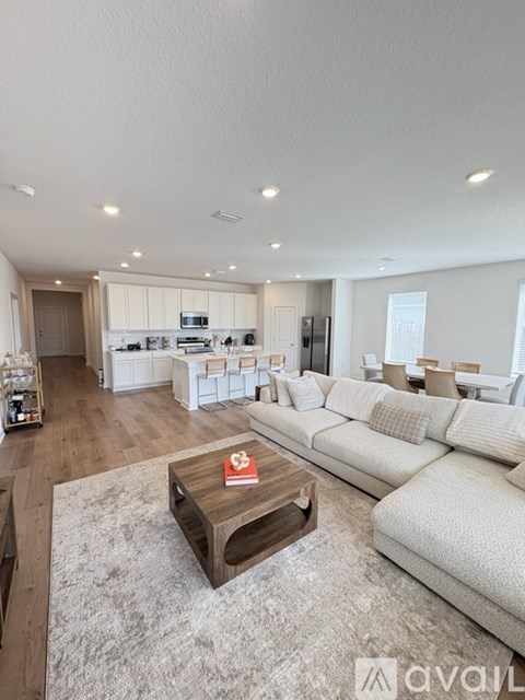 A modern living room with a white sofa and a wooden coffee table.