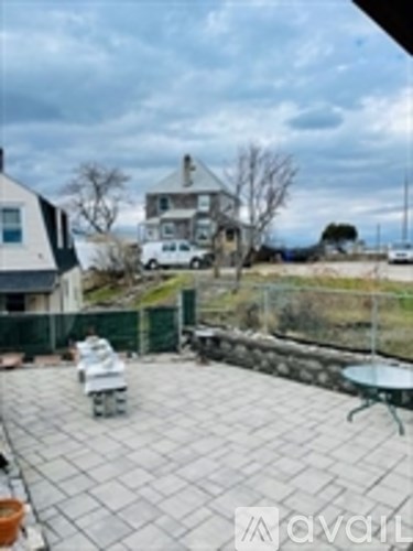 A patio with a table and chairs overlooking a yard.
