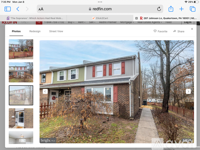 A house with a red door is shown on a real estate website.