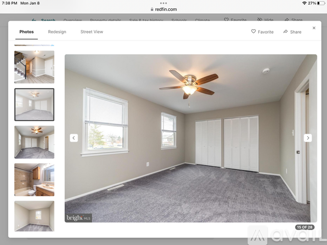 A spacious room with a ceiling fan and carpeted floor.