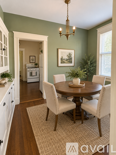 A dining room with a round table and chairs.