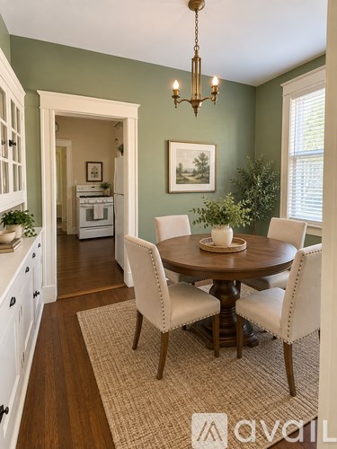 A dining room with a round table and chairs.